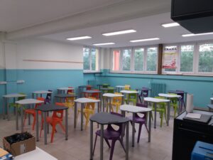 aula della scuola secondaria di primo grado di villafranca con lavagna interattiva, pareti bianche e azzurre e banchi con sedie di vari colori