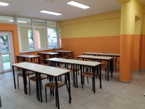 aula della scuola secondaria di primo grado di villafranca con lavagna interattiva, pareti gialle ed arancioni e banchi con sedie di vari colori